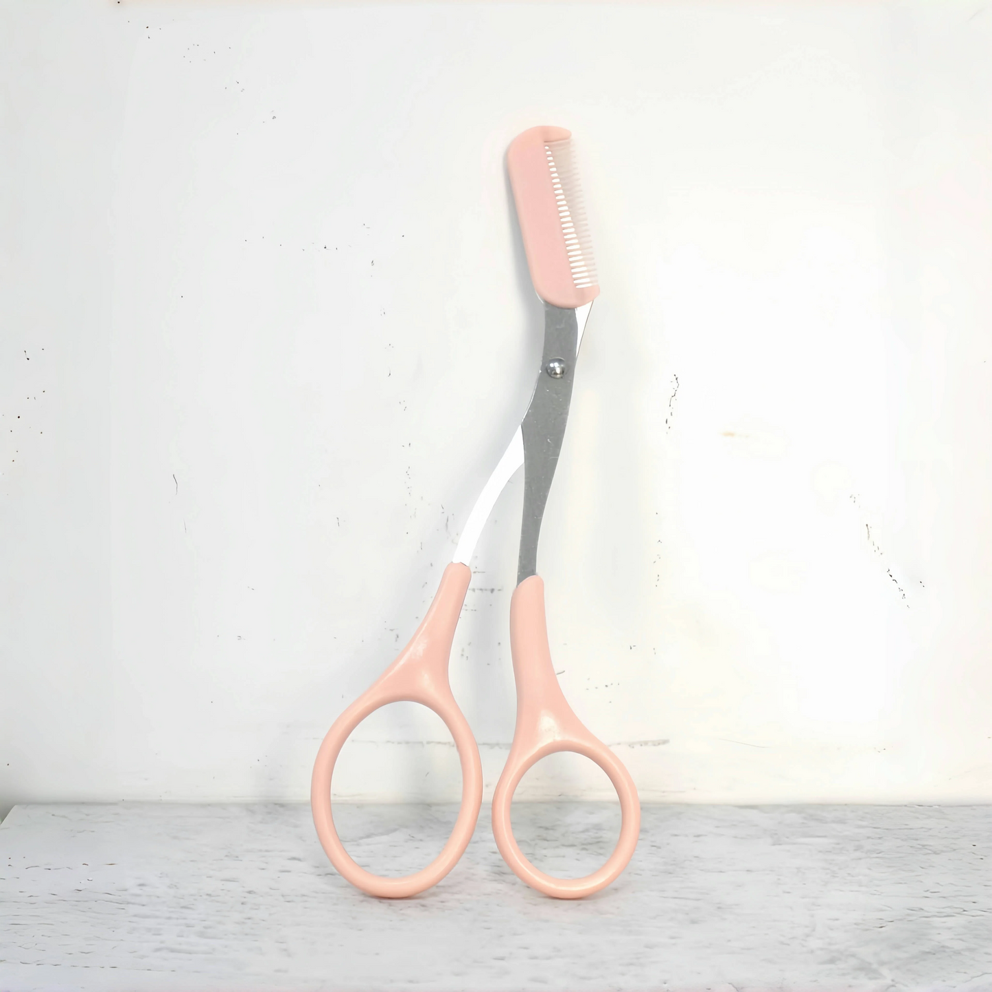 Pink eyebrow trimming scissors with built-in comb