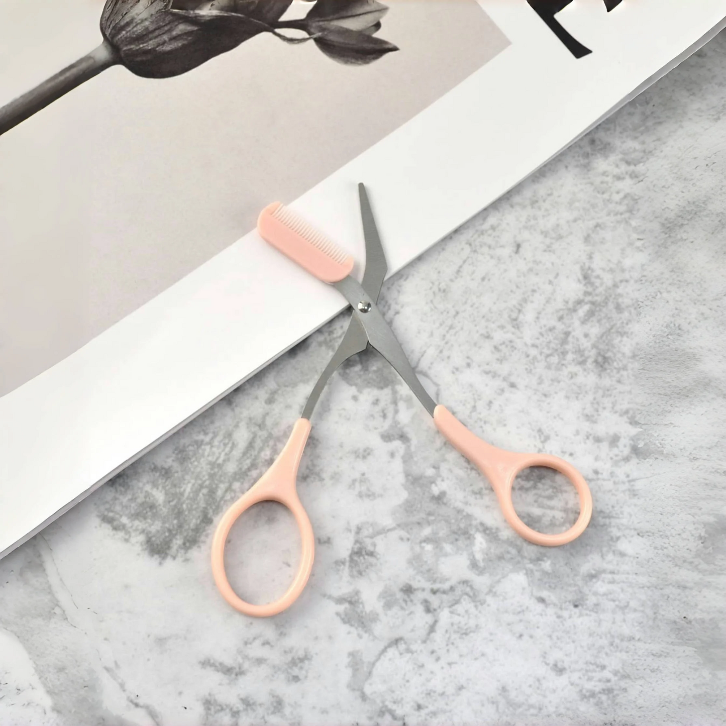 Pink eyebrow trimming scissors with built-in comb